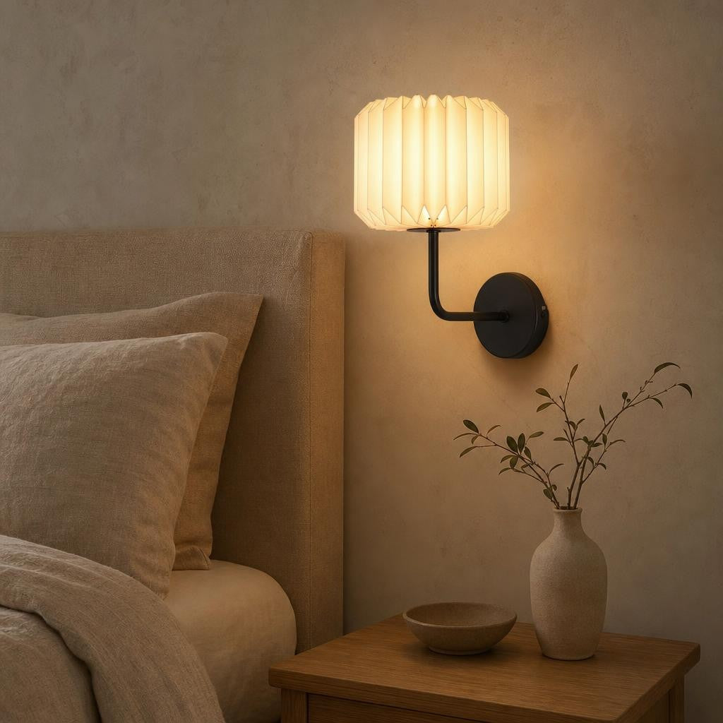 Applique Oru allumée au-dessus d'une table de chevet dans une chambre