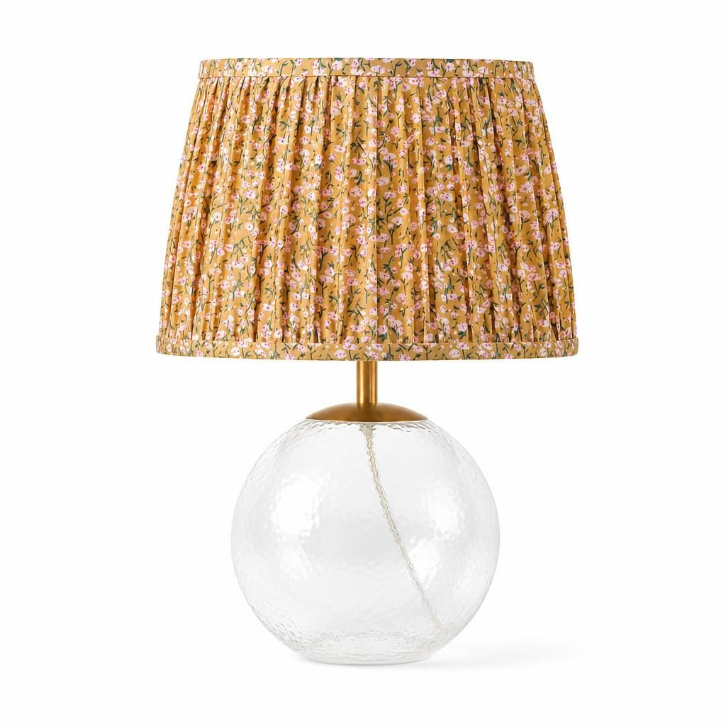 Lampe à poser Nobara, pied boule en verre martelé et abat-jour plissé fleuri ocre, sur fond blanc