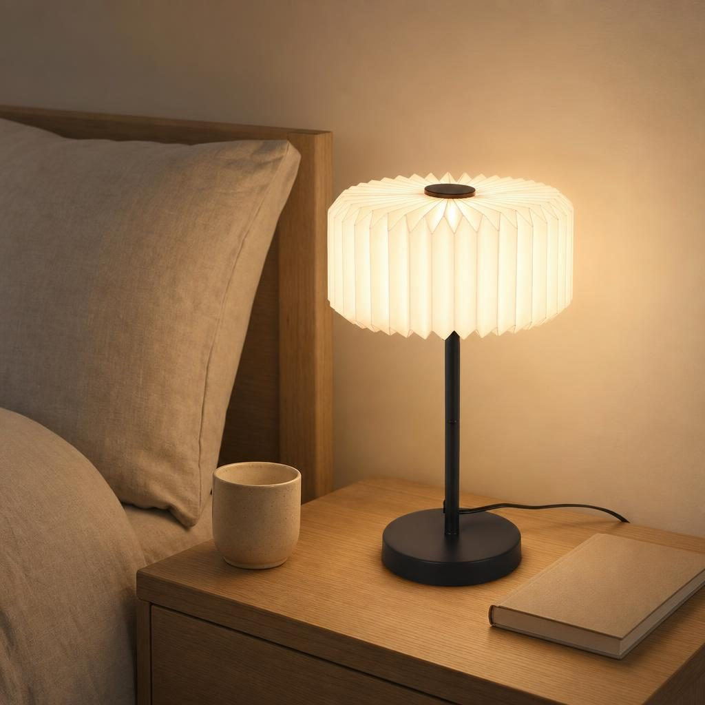 Lampe Sensu allumée sur une table de chevet en chêne dans une chambre Japandi